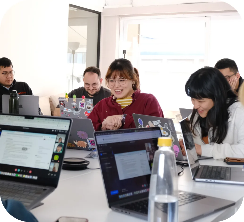 The PicCollage team working together around a table of laptops